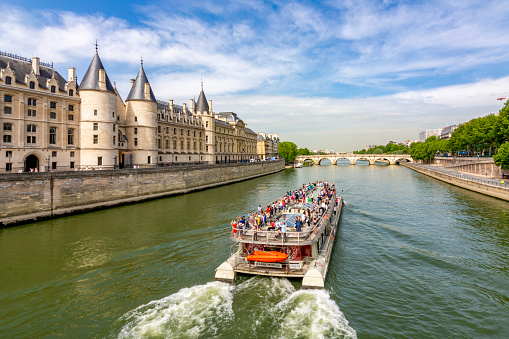 Paris, France - May 2019: Trip boat sailing along Seine river in Paris