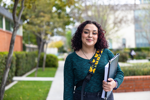 A young latino female college student on campus.