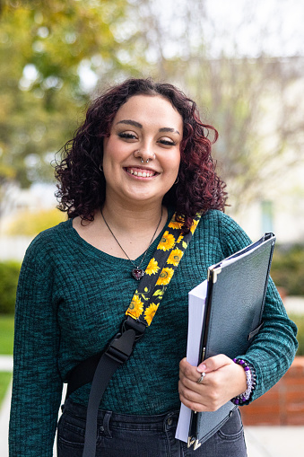 A young latino female college student on campus.