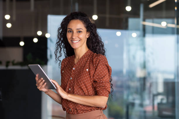 istock Young and successful female programmer, portrait of female engineer with tablet computer startup worker working inside office building using tablet for testing applications smiling looking at camera 1963249796