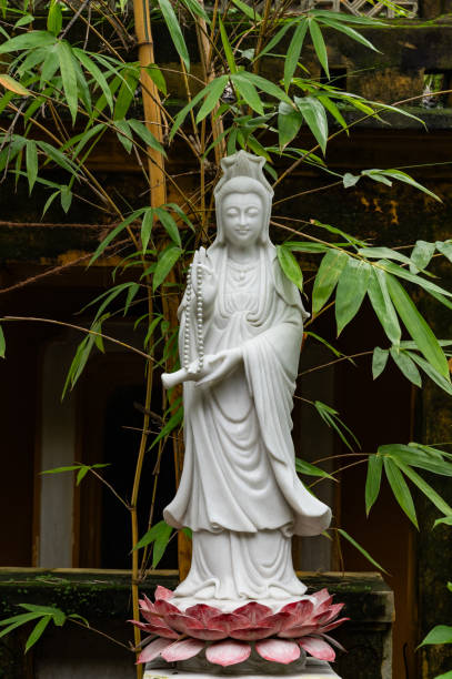 istock Standing Buddha Statue in a Lush Green Garden 1963315790