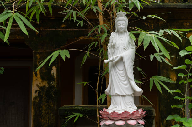istock Standing Buddha Statue in a Lush Green Garden 1963331772