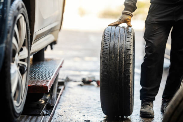 istock Cropped picture of a vulcanizing worker with car tire in workshop. 1963334373
