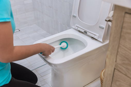 Teenager cleaning modern bathroom