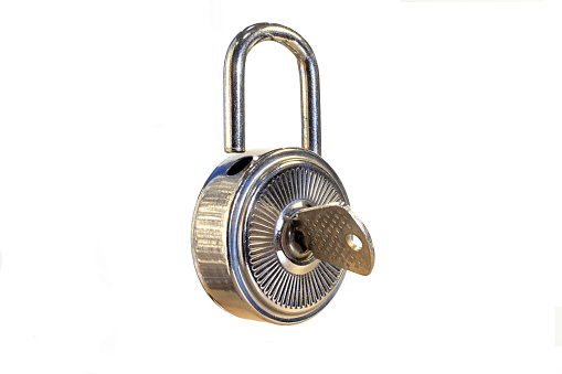 A round padlock with a key on a white background.