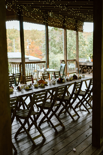 A fall tablescape decor with numerous chairs adorned with string lights