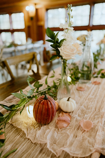 A fall tablescape decor adorned with white flowers and pumpkins