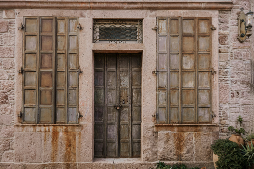 Iron door and closed windows of an old house. stock photo