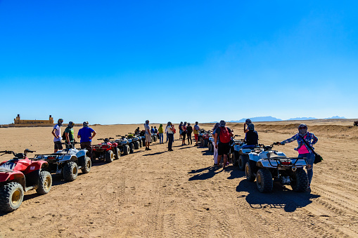 Hurghada, Egypt - December 10, 2018: Unrecognizable people near quad bikes during safari trip in Arabian desert not far from Hurghada city, Egypt