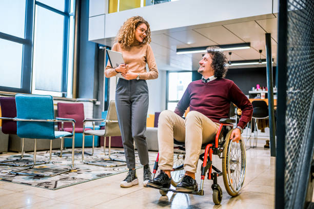 istock Woman talking with her disabled coworker 1963410524