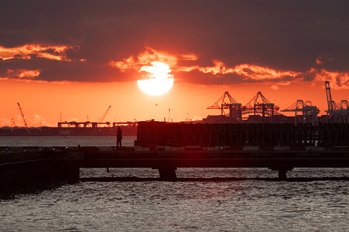 Dock worker on the pier during sunset