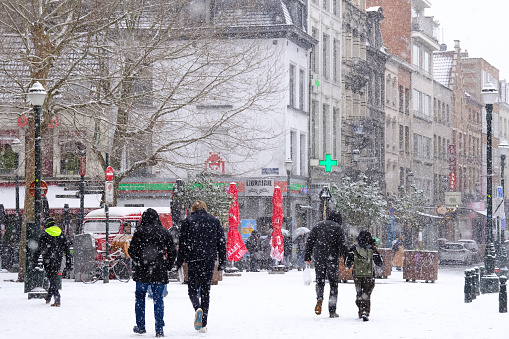 People walk in central Brussels during a heavy snowfall in Belgium on January 17, 2024.