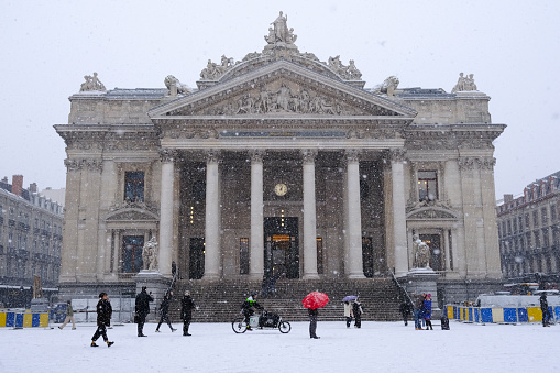 People walk in central Brussels during a heavy snowfall in Belgium on January 17, 2024.