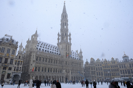People walk in the snow covered Grand Place after heavy snowfall hit Brussels in Belgium on January 17, 2024.