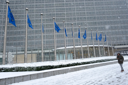 People walk in outside of EU headquarters during a heavy snowfall in Brussels, Belgium on January 17, 2024.