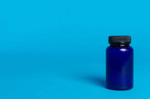 supplement pills with medicine bottle health care and medical top view. Vitamin tablets. Top view mockup bottle for pills and vitamins with green leaves, natural organic bio supplement, copy space.
