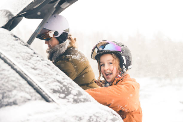 Mother and daughter getting unpacking the car for skiing stock photo