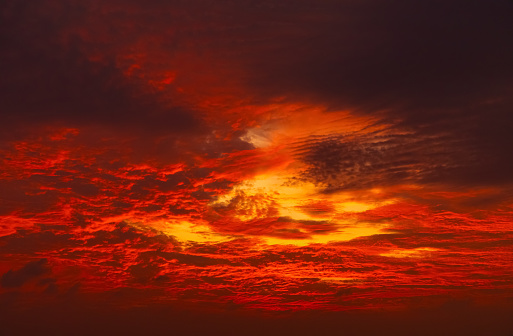 Dramatic red-orange blurred background of the setting sun. Abstract natural background