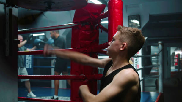 istock Focused young fighter hits punching bag during workout 1963549195
