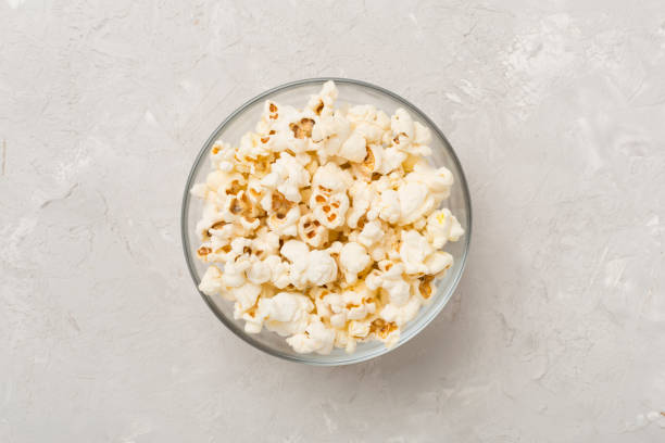 istock Tasty popcorn in bowl on concrete background, top view 1963680609