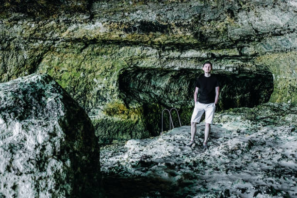 istock A young guy stands in a cave after low tide. 1963689311