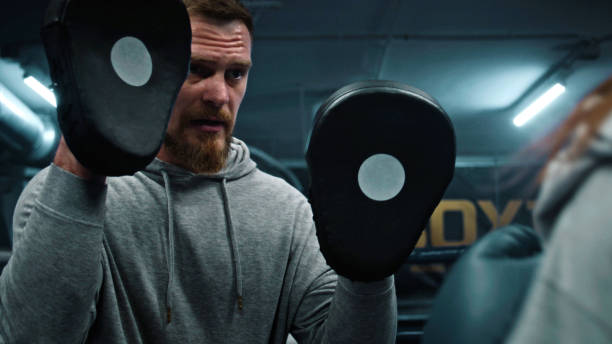 istock Woman exercises with male trainer before fighting match 1963705814