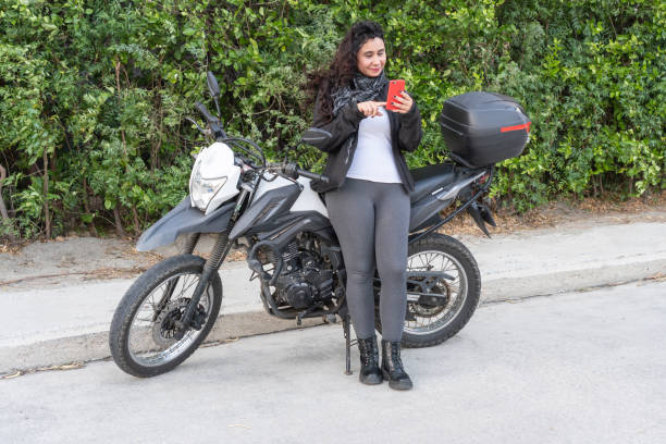 istock Female Motorcyclist Texting Outdoors 1963789417