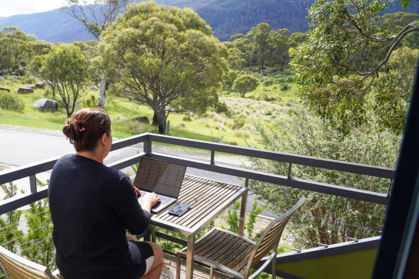 istock A woman working remotely from her balcony looking over bushland and mountains 1963790456