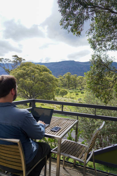 istock Male working remotely from his balcony looking over the mountains 1963790459