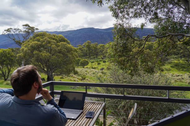 istock Male working remotely from his balcony looking over the mountains 1963791488