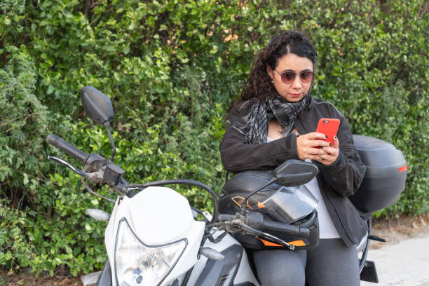 istock Biker Woman Engrossed in Smartphone 1963796712