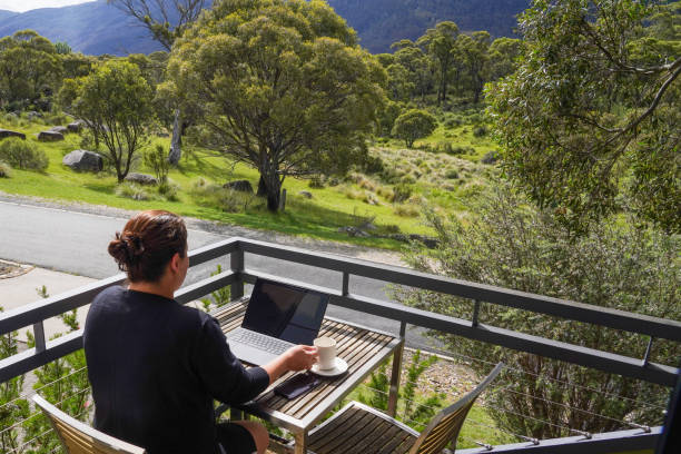istock A woman working remotely from her balcony looking over bushland and mountains 1963797758