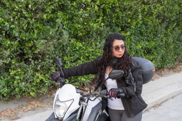istock Young woman in biker gear with motorcycle, ready for a ride. 1963801938