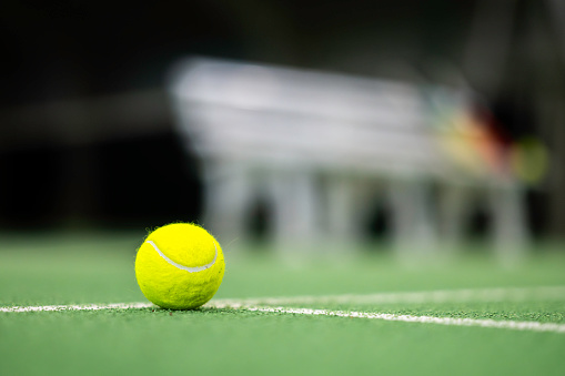 Tennis ball on court green floor close up selective focus
