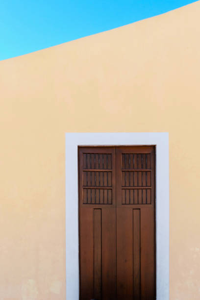 istock wood vintage door with yellow facade 1963894705
