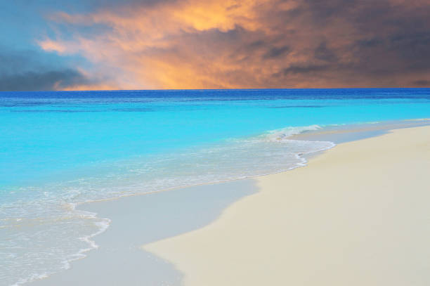 Waves on beach in Maldivian sea under dramatic sky