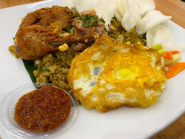 istock Fried rice on a white plate with fried chicken and omelet as side dishes, looks like chili peppers and crackers add to the deliciousness of this food 1963952049