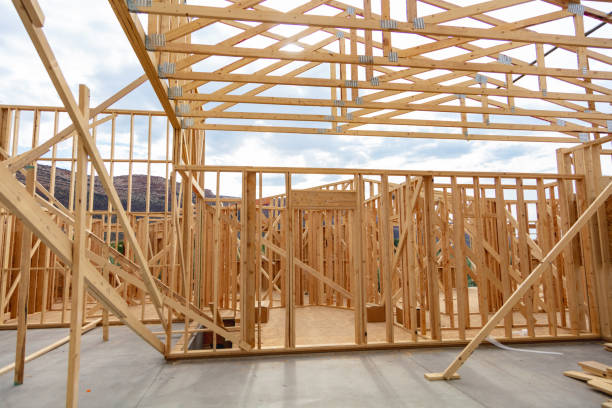 An ongoing construction site in the suburbs, featuring the framing stage of a single-family house.