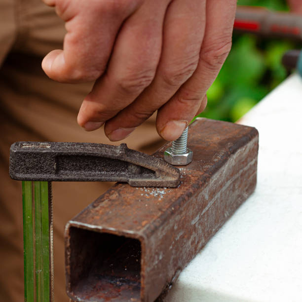 istock Working with metal. A man's hand screws a bolt into a metal nut 1963993191