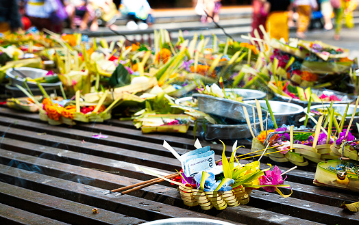 You'll find lots of Balinese offerings everywhere while you walk down streets in Bali. They are made from coconut leaves and filled with colorful flowers and fruits.  You might see notes in some of them. I saw almost everybody made small offerings everyday and left them on the street or in front of houses. These are ritual and very religious things.