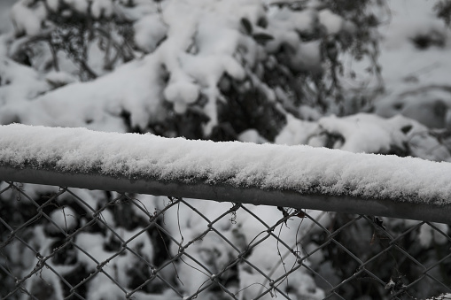 Scenery of snow accumulating on wire mesh