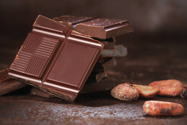 istock Broken dark chocolate and chocolate flakes on a wooden table 1964114090