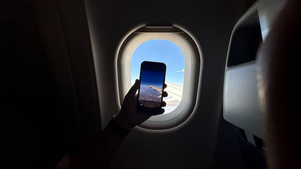 istock Person holding a cellphone on the plane 1964155932