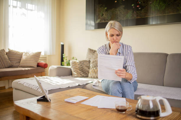 istock Young woman using calculator while going through bills and home finances 1964190174