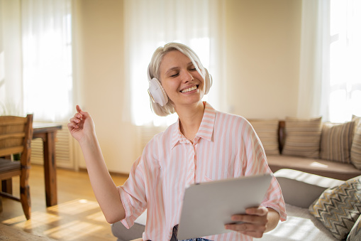 Cheerful young woman is enjoying the music