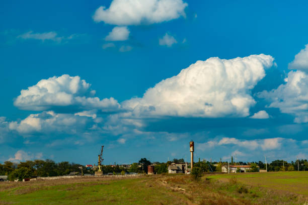 White cumulus thunderclouds in the sky over a highway, Ukraine