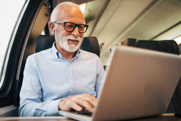 istock An elderly passenger works on a laptop on the train 1964220223