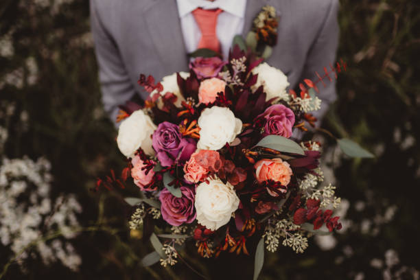 Groom holding brightly colored wedding bouquet