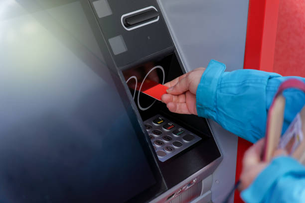 istock woman inserting her credit card in an ATM machine 1964278766