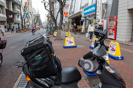 Suita, Osaka, Japan - January 20, 2024 : Uber Eats delivery bag on scooter in Suita, Osaka, Japan.